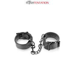 Menottes simili cuir ajustables Fetish Tentation, la paire reliée par la chaînette noire.